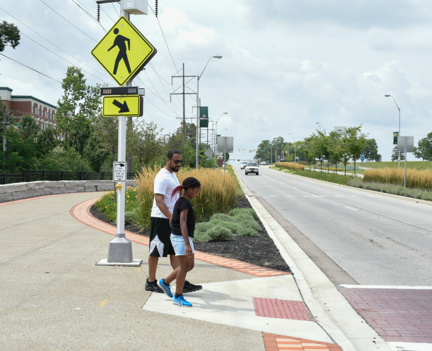 Two people crossing the street at crosswalk