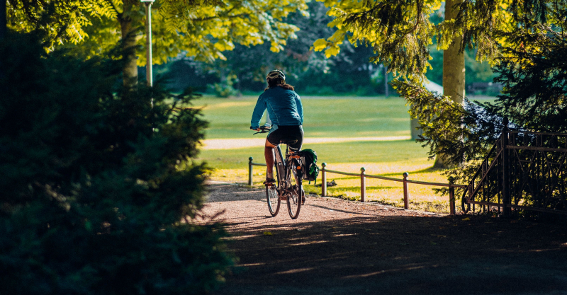 A biker out on a bike ride on a summer afternoon.