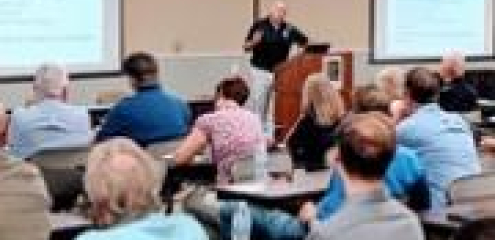 Attendees listen to a presentation during a stormwater management seminar in a meeting room.